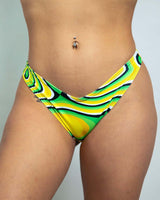 Cheeky low-waisted Brazilian bikini bottoms in vibrant green and yellow patterns, perfect for rave outfits and festivals.